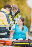 Emergency medics dressing head wound of injured woman Royalty Free Stock Photography Emergency medics dressing head wound of injured woman Royalty Free Stock Photography