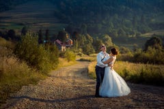 Emotional full-length shot of the cheerful newlywed couple laughing and having fun during the walk along the countryside royalty free stock images Emotional full-length shot of the cheerful newlywed couple laughing and having fun during the walk along the countryside royalty free stock images