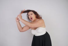 Emotionale ungl?ckliche Frau mit den ungepflegten Haarversuchen, zum sie zu k?mmen und leidet curvy M?dchen steht auf wei?em Hint stockfoto Emotionale ungl?ckliche Frau mit den ungepflegten Haarversuchen, zum sie zu k?mmen und leidet curvy M?dchen steht auf wei?em Hint stockfoto