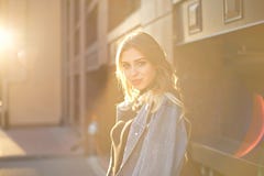 Emotioneel modieus portret van een jonge blonde vrouw op een cityscape achtergrondclose-up in de het plaatsen zon royalty-vrije stock afbeelding Emotioneel modieus portret van een jonge blonde vrouw op een cityscape achtergrondclose-up in de het plaatsen zon royalty-vrije stock afbeelding