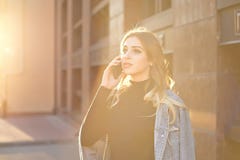 Emotioneel modieus portret van een jonge blonde vrouw op een cityscape achtergrondclose-up in de het plaatsen zon stock fotografie Emotioneel modieus portret van een jonge blonde vrouw op een cityscape achtergrondclose-up in de het plaatsen zon stock fotografie