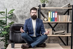 Emp?chez le burn-out professionnel Le costume formel de directeur barbu d'homme reposent la d?tente de pose de lotus Mani?re de d photos stock Emp?chez le burn-out professionnel Le costume formel de directeur barbu d'homme reposent la d?tente de pose de lotus Mani?re de d photos stock