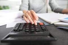 Empregado de escritório que trabalha com calculadora e documentos na tabela foto de stock Empregado de escritório que trabalha com calculadora e documentos na tabela foto de stock