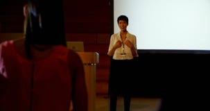 Empresaria joven que hace preguntas al altavoz femenino asi?tico durante seminario en el auditorio 4k almacen de metraje de vídeo Empresaria joven que hace preguntas al altavoz femenino asi?tico durante seminario en el auditorio 4k almacen de metraje de vídeo