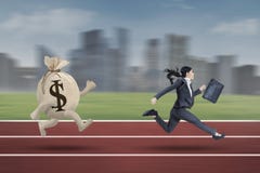Empresaria que corre con un bolso del dólar imagen de archivo Empresaria que corre con un bolso del dólar imagen de archivo