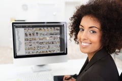 Empresaria sonriente que corrige las fotografías imagenes de archivo Empresaria sonriente que corrige las fotografías imagenes de archivo