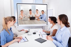Empresarios que asisten a videoconferencia foto de archivo Empresarios que asisten a videoconferencia foto de archivo