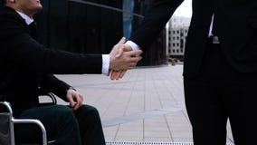 Empresário feliz que agita as mãos com o homem de negócios inválido exterior vídeos de arquivo Empresário feliz que agita as mãos com o homem de negócios inválido exterior vídeos de arquivo