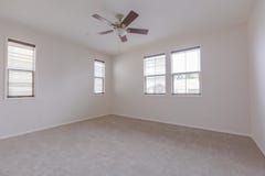 Empty bedroom with clean carpets and fan stock image Empty bedroom with clean carpets and fan stock image