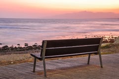 Empty Bench Beside The Sea At Sunset. Stock Photo