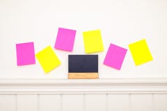 Empty colorful sticky notes and little blackboard on the wall . stock photo Empty colorful sticky notes and little blackboard on the wall . stock photo