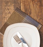 Empty Dish, Knife And Fork And Brown Napkin Royalty Free Stock Image