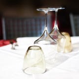 Empty glasses set in restaurant with wine glasses and plates for stock image Empty glasses set in restaurant with wine glasses and plates for stock image