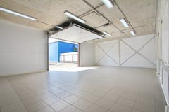 Empty parking garage, warehouse interior with large white gates and gray tile floor stock photos Empty parking garage, warehouse interior with large white gates and gray tile floor stock photos