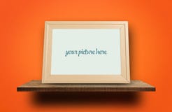 Empty photo frame on wooden shelves orange wall royalty free stock photography Empty photo frame on wooden shelves orange wall royalty free stock photography