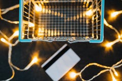 Empty shopping cart and payment card next to it on concrete desk surrounded by fairy lights stock photo Empty shopping cart and payment card next to it on concrete desk surrounded by fairy lights stock photo