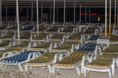 Empty striped loungers by the sea in the evening stock image Empty striped loungers by the sea in the evening stock image