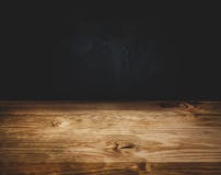 Empty wood table top counter on dark wall background