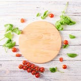 Empty wooden cutting board with tomatoes and basil stock image Empty wooden cutting board with tomatoes and basil stock image