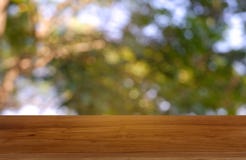 Empty wooden table in front of abstract blurred green of garden and nature light background. For montage product display or design stock photo Empty wooden table in front of abstract blurred green of garden and nature light background. For montage product display or design stock photo