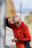 En aktiv jogga pensionär som ser hans smartwatch arkivfoton En aktiv jogga pensionär som ser hans smartwatch arkivfoton