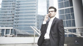 En allvarlig affärsman talar på telefonen på trappan arkivfoto En allvarlig affärsman talar på telefonen på trappan arkivfoto