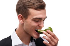 En attraktiv bartender biter en saftig grön limefrukt, coctailar i en nattklubb på vit bakgrund arkivfoton En attraktiv bartender biter en saftig grön limefrukt, coctailar i en nattklubb på vit bakgrund arkivfoton