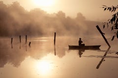 En dimmig morgon vid sjön Liten fiskebåt på sjön royaltyfri foto En dimmig morgon vid sjön Liten fiskebåt på sjön royaltyfri foto