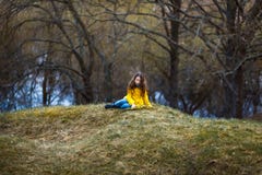 En flicka i ett gult lag i skogen i tidig vår med en pilfilial av ris En flicka som pälsfodrar fresheten eller högt vatten arkivbilder En flicka i ett gult lag i skogen i tidig vår med en pilfilial av ris En flicka som pälsfodrar fresheten eller högt vatten arkivbilder