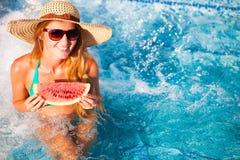 En flicka rymmer halva en röd vattenmelon över en blå pöl, avslappnande nolla royaltyfria bilder En flicka rymmer halva en röd vattenmelon över en blå pöl, avslappnande nolla royaltyfria bilder