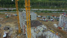 En flyg- sikt av konstruktionsplatsen nära det gröna stora bostads- komplexet för skog A är under konstruktionen med lager videofilmer En flyg- sikt av konstruktionsplatsen nära det gröna stora bostads- komplexet för skog A är under konstruktionen med lager videofilmer