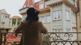 En gladlynt flicka i ett långt lag bär en svart stilfull hatt ankom för första gången i Europa, vinkar hennes hand till förbipass lager videofilmer En gladlynt flicka i ett långt lag bär en svart stilfull hatt ankom för första gången i Europa, vinkar hennes hand till förbipass lager videofilmer