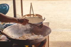 En handkock gör pinnar för stekte ris med räka i gatamat arkivbilder En handkock gör pinnar för stekte ris med räka i gatamat arkivbilder