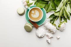 En kopp kaffe på en vit tabell med pioner, sötsaker och frukter royaltyfri fotografi En kopp kaffe på en vit tabell med pioner, sötsaker och frukter royaltyfri fotografi