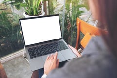 En kvinna som använder och trycker på bärbar datortouchpaden med den vita skrivbords- skärmen för mellanrum, medan sitta i kafé royaltyfri bild En kvinna som använder och trycker på bärbar datortouchpaden med den vita skrivbords- skärmen för mellanrum, medan sitta i kafé royaltyfri bild