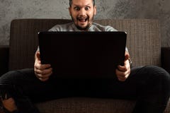 En man h?ller ?gonen p? en vuxen video p? en b?rbar dator, medan sitta p? soffan Begreppet av pornografi, m?ns behov, pervers man fotografering för bildbyråer En man h?ller ?gonen p? en vuxen video p? en b?rbar dator, medan sitta p? soffan Begreppet av pornografi, m?ns behov, pervers man fotografering för bildbyråer