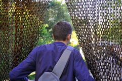En man i en zoo skriver in en frilufts- bur till f?glar igenom royaltyfri bild En man i en zoo skriver in en frilufts- bur till f?glar igenom royaltyfri bild