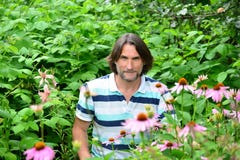 En man nära blomsterrabatterna i trädgården Fotografering för Bildbyråer En man nära blomsterrabatterna i trädgården Fotografering för Bildbyråer
