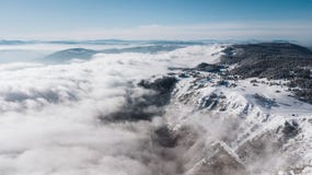 En sikt uppifrån av berget till klipporna som täckas med snö och, sörjer dalen med en klar blå himmel på en solig dag royaltyfria foton En sikt uppifrån av berget till klipporna som täckas med snö och, sörjer dalen med en klar blå himmel på en solig dag royaltyfria foton