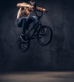 En stilig man med BMX i en studio royaltyfria foton En stilig man med BMX i en studio royaltyfria foton