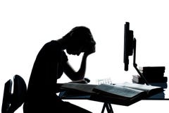 En tonåringsilhouette som studerar med datoren royaltyfri fotografi En tonåringsilhouette som studerar med datoren royaltyfri fotografi