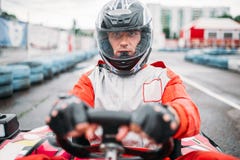 En transportant en charrette la course, allez conducteur de kart dans le casque, vue de face images libres de droits En transportant en charrette la course, allez conducteur de kart dans le casque, vue de face images libres de droits