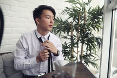 En ung asiatisk affärsman väntar på en partner i ett kafé Bu royaltyfri fotografi En ung asiatisk affärsman väntar på en partner i ett kafé Bu royaltyfri fotografi