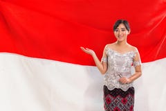 En ung dam som introducerar gester, indonesisk flagga i bakgrunden arkivfoton En ung dam som introducerar gester, indonesisk flagga i bakgrunden arkivfoton