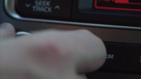 En ung man justerar volymen av musiken i bilen stock video En ung man justerar volymen av musiken i bilen stock video