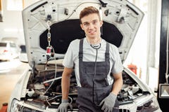 En ung man är på arbete på en bilservice royaltyfria foton En ung man är på arbete på en bilservice royaltyfria foton