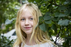 En verano, la muchacha rubia de ojos azules es un adolescente en el foliag Fotografía de archivo En verano, la muchacha rubia de ojos azules es un adolescente en el foliag Fotografía de archivo