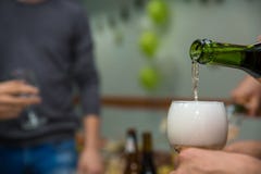 En versant le champagne dans le verre à la poule-partie, fermez-vous photo libre de droits En versant le champagne dans le verre à la poule-partie, fermez-vous photo libre de droits