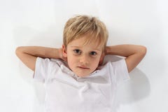 En älskvärd preteen pojke som satisfyingly ligger på jordningen fotografering för bildbyråer En älskvärd preteen pojke som satisfyingly ligger på jordningen fotografering för bildbyråer