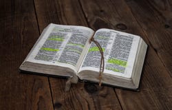 En öppen bibel och ett guld- kors på träbakgrund royaltyfri foto En öppen bibel och ett guld- kors på träbakgrund royaltyfri foto